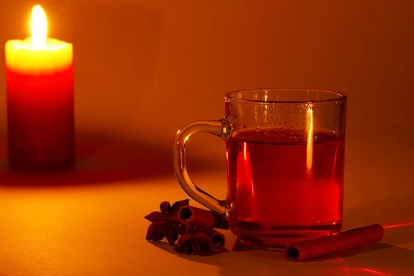 Red tea cinnamon sticks star anise at candle light — Stock Photo, Image