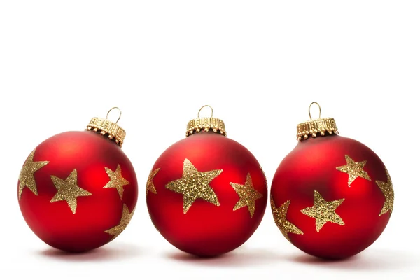 Drie rode saai kerstballen met gouden glitter sterren — Stockfoto
