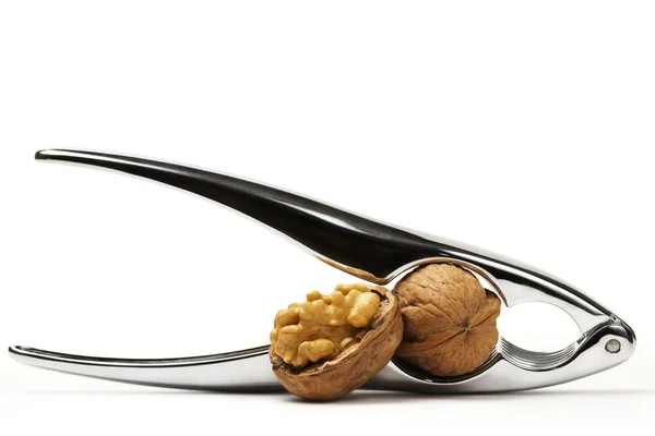 Nutcracker with closed and cracked walnuts — Stock Photo, Image
