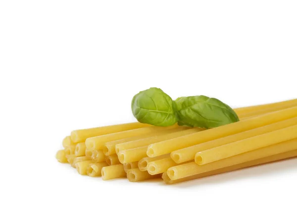 Сырые макароны с базиликом — стоковое фото