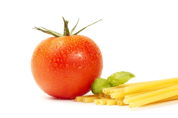 Сырые макароны с базиликом и помидорами — стоковое фото