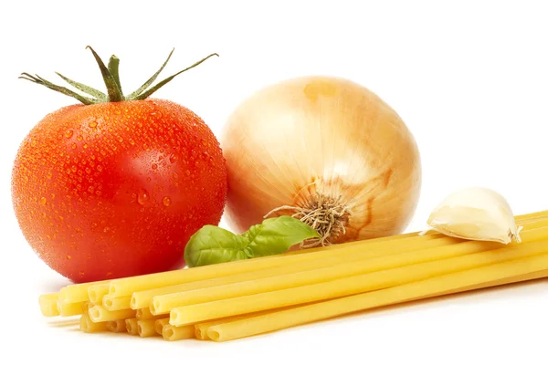 Сырые макароны с базиликом, помидорами, луком и чесноком — стоковое фото