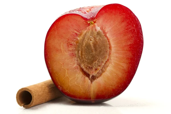 Half wet plum with a cinnamon stick — Stock Photo, Image