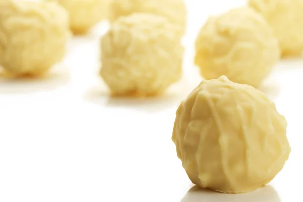 Yellow truffle praline in front of many — Stock Photo, Image