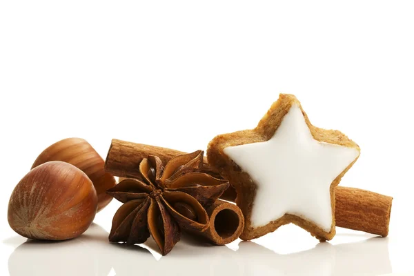 Biscuit à la cannelle en forme d'étoile, bâtonnets de cannelle et noisettes — Photo
