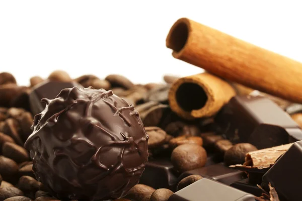 Trufa frente a palitos de canela y granos de café en una barra de chocolate —  Fotos de Stock