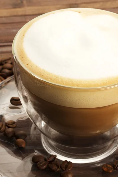 Cappuccino w filiżance szkła na drewniane tła — Zdjęcie stockowe