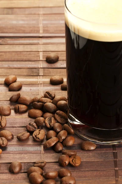 Granos de café cerca de café negro —  Fotos de Stock