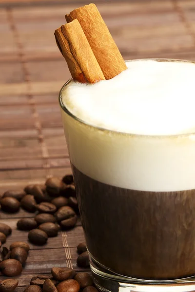 Espresso in a short glass with milk froth and cinnamon inside — Stock Photo, Image
