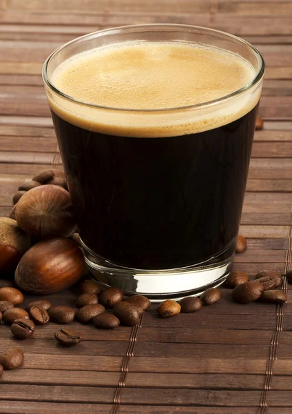 Espresso coffee in a short glass with hazelnuts — Stock Photo, Image