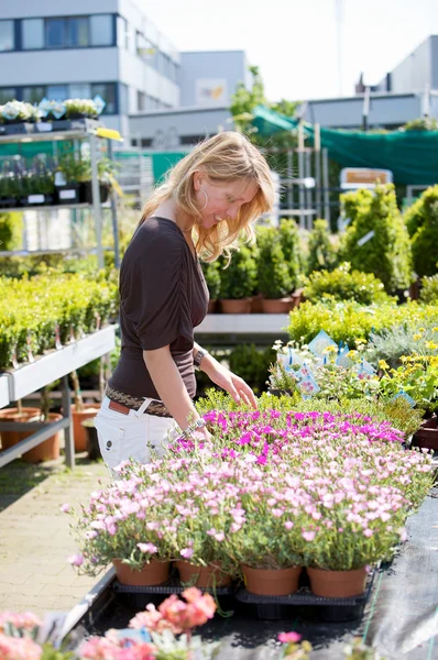 Pretty blond woman in gardening center — Stock Photo, Image