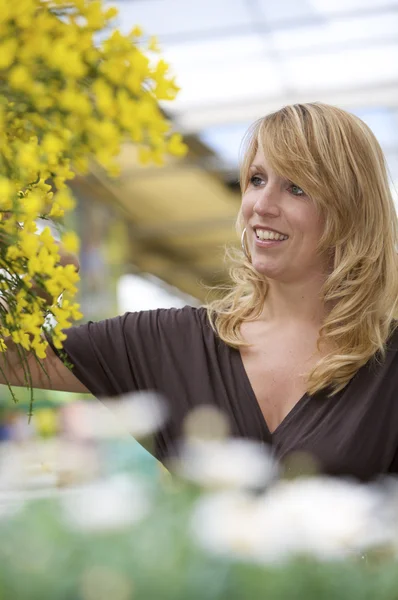Söt blond kvinna i garden center — Stockfoto