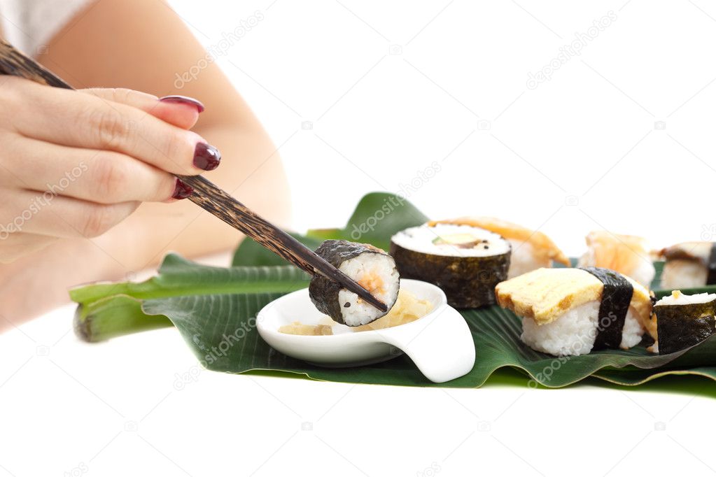 Woman hand eating sushi