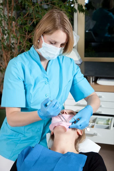 Dentista do sexo feminino trabalhando em seu paciente — Fotografia de Stock