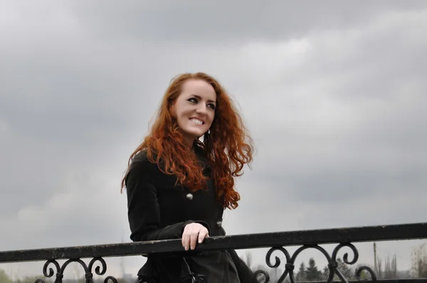 सुंदर लाल बालों वाली लड़की पुल पर मुस्कुराते हुए — स्टॉक फ़ोटो, इमेज