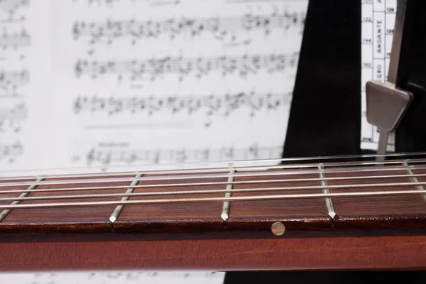 Cuello de guitarra de primer plano, notas, metrónomo — Foto de Stock