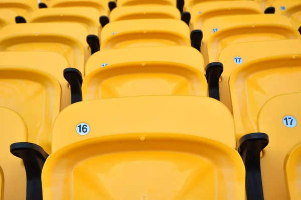 Ряд желтое сиденье на футбольном стадионе — стоковое фото