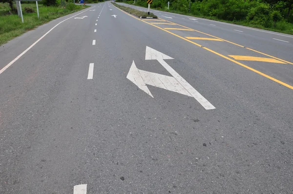 Seta símbolo de tráfego na estrada de asfalto — Fotografia de Stock