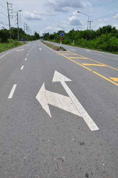 Seta símbolo de tráfego na estrada — Fotografia de Stock