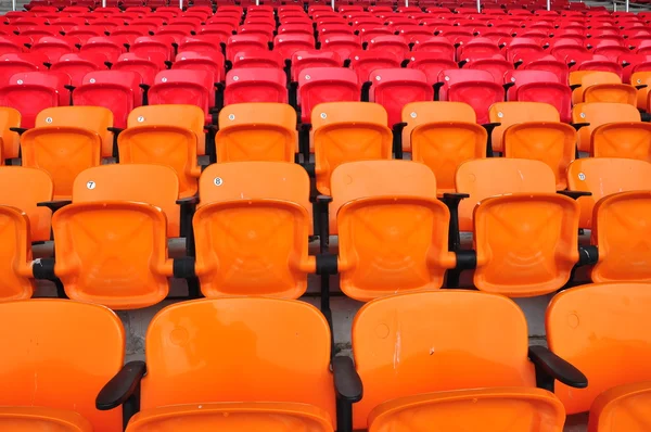 Оранжевый и красный сиденья на стадионе — стоковое фото