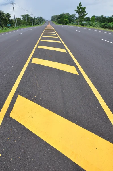 Желтая линия на асфальтированной дороге — стоковое фото