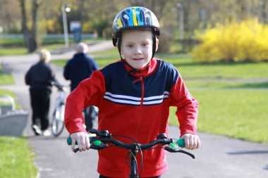 Young boy on bike. clipart