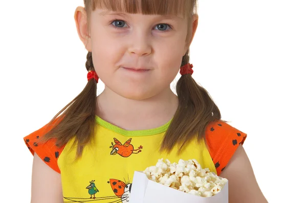 Klein meisje houdt pakket met popcorn Stockfoto