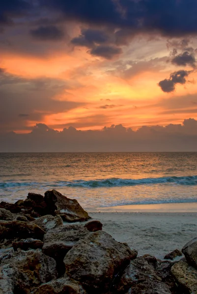 Захід сонця над скелястим пляжем — стокове фото