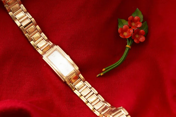 Womens Golden Watch sobre fundo vermelho — Fotografia de Stock