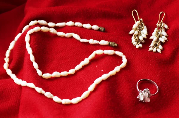 Kalung dan perhiasan pada latar belakang satin mewah — Stok Foto