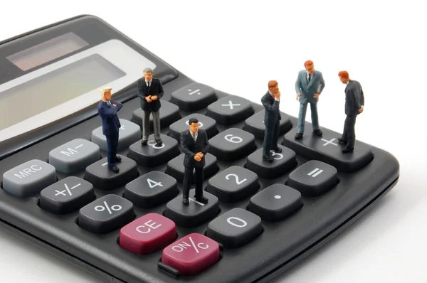 Игрушечный бизнесмен на калькуляторе изолирован — стоковое фото