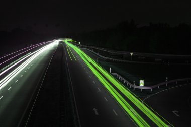 Road with car traffic at night with blurry lights clipart