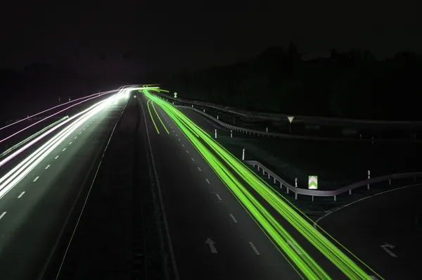 Estrada com trânsito de carro à noite com luzes embaçadas — Fotografia de Stock