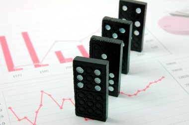 Risky domino over a financial business chart clipart