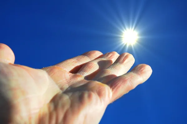 Hand zon en blauwe lucht — Stockfoto