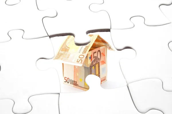 Puzzle e dinheiro casa — Fotografia de Stock