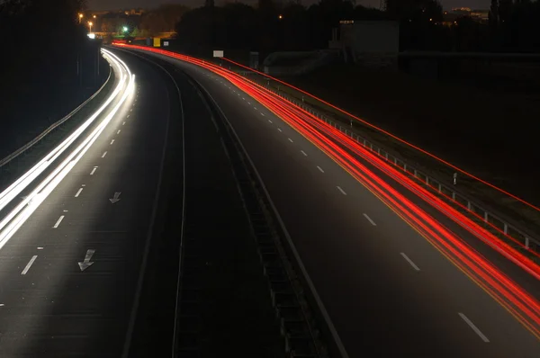 Bulanık ışıkları ile gece araba trafiği olan yol — Stok fotoğraf