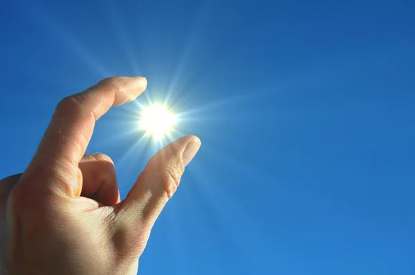手太阳和蓝色的天空 — 图库照片