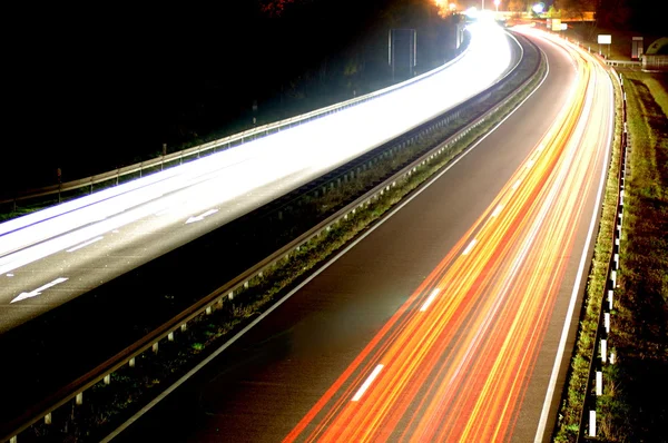 Carretera con tráfico de coche por la noche con luces borrosas — Foto de Stock