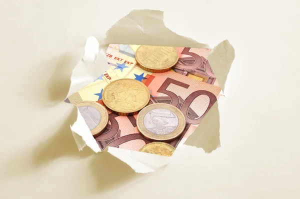 Euro geld achter gat in papier — Stockfoto