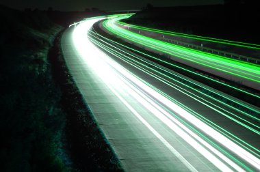 Road with car traffic at night with blurry lights clipart