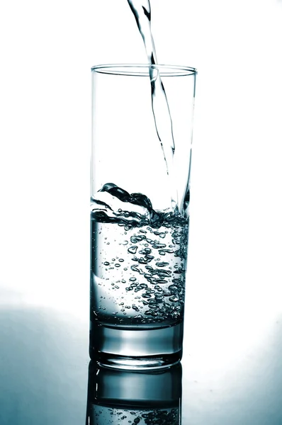 Glass of pouring water with reflection — Stock Photo, Image