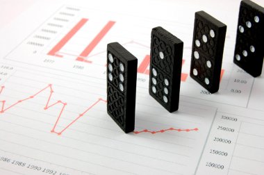 Risky domino over a financial business chart clipart