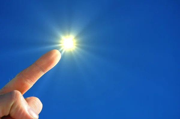 Рука солнце и голубое небо — стоковое фото