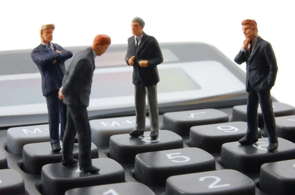Игрушечный бизнесмен на калькуляторе изолирован — стоковое фото