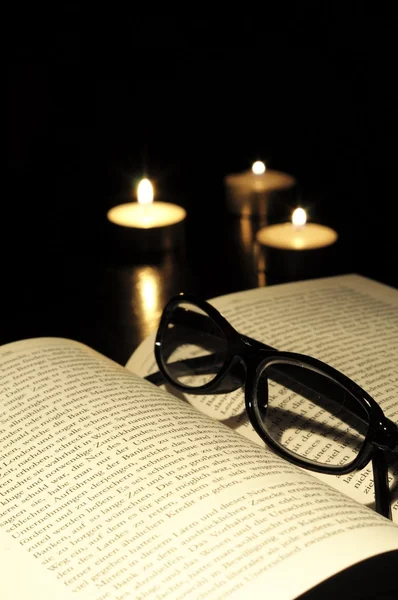 Świeca książki i okulary — Zdjęcie stockowe