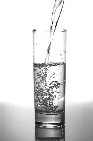 Copo de água de vazamento com reflexão — Fotografia de Stock