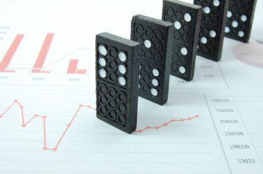 Risky domino over a financial business chart clipart