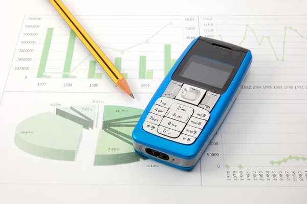 Mobiele telefoon over zakelijke grafiek — Stockfoto