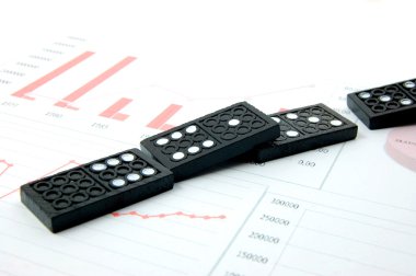 Risky domino over a financial business chart clipart